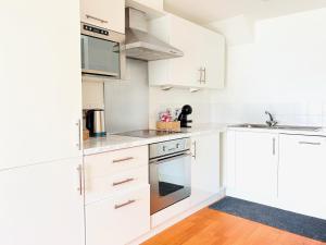 une cuisine blanche avec des armoires blanches et un évier dans l'établissement York City Centre 2-Bed Flat - Top Location, à York