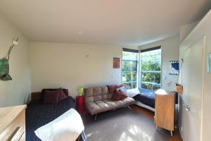 a living room with a couch and a window at beach bush retreat at Leigh in Leigh