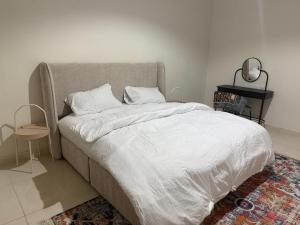 a bed with white sheets and pillows in a bedroom at أستديو كلاود السحاب in Al Baha