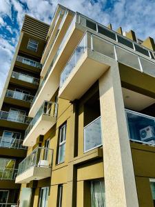 Un edificio amarillo con balcones a los lados. en Patio Belgrano, en Salta