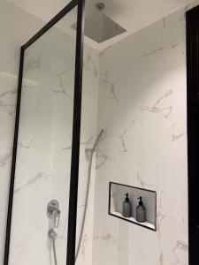 a shower with a glass door with two vases at FARAH LUXURY WITH cinema room in Dhahran