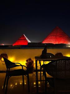 a cat sitting on a table in front of the pyramids at Horus pyramids view in Cairo