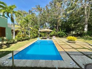 Isla de BaruにあるBeautiful villa in a condominium facing the Caribbean seaの木々の茂る庭の青いスイミングプール