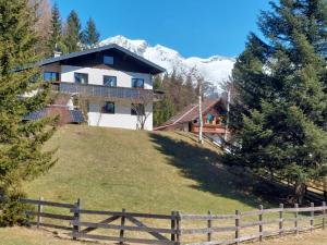 a house on top of a hill with a fence at Landhaus Herz der Tauern in Mallnitz