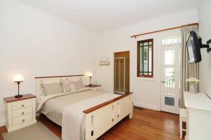Un dormitorio blanco con una cama grande y una ventana. en Rivermist Luxury 6 bedrooms and 6 bathrooms, en Valle Kangaroo