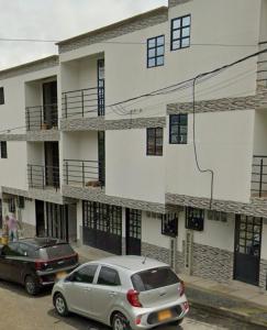 zwei Autos vor einem Gebäude geparkt in der Unterkunft Bulevar Santa Rosa, apartamento nuevo y acogedor in Santa Rosa de Cabal
