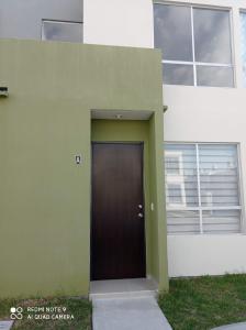 ein Gebäude mit einer braunen Tür davor in der Unterkunft Las Palmas in Concepción del Valle