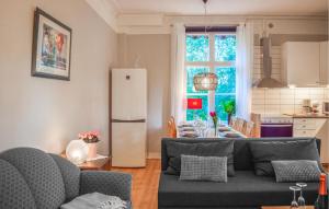 a kitchen and a living room with a table and a refrigerator at Cozy Apartment In Storfors With Wifi in Storfors