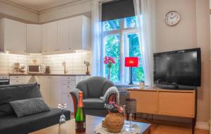 a living room with a couch and a tv at Cozy Apartment In Storfors With Wifi in Storfors +6 photos