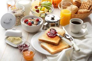 a breakfast table with toast and a bowl of fruit at ASURE Chelsea Gateway Motor Lodge in Westport