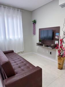 ein Wohnzimmer mit Couch und Flachbildfernseher in der Unterkunft Residencial Spader - Bombinhas in Bombinhas + 44 Fotos