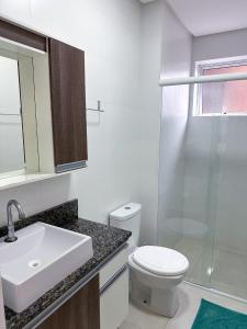 a bathroom with a toilet and a sink and a shower at Residencial Spader - Bombinhas in Bombinhas