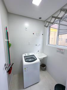 ein kleines Badezimmer mit Toilette und Waschbecken in der Unterkunft Residencial Spader - Bombinhas in Bombinhas