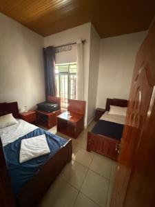 a small bedroom with two beds and a window at House of Rein in Ruhengeri