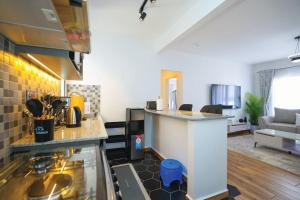 a kitchen with a counter top and a living room at Premium Luxury 2-Bedroom Apartment in Tatu City