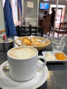 a cup of coffee on a table with a plate of bread at Virgen Del Valle Alojamiento in Tafí del Valle +33 photos