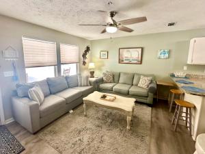 una sala de estar con un sofá y una mesa en Peachy Palm, en Panama City Beach