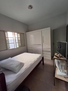a bedroom with a bed and a desk with a television at Refúgio São Jorge in São José dos Campos