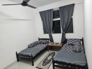 a living room with two beds and a window at Homestay Saderi Putrajaya Presint 16 in Putrajaya