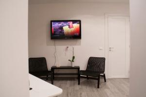 a living room with two chairs and a tv on the wall at DaNoi in Trastevere in Rome