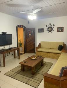 a living room with a couch and a tv at Casa em Ilhabela - Próxima à Praia do Curral in Ilhabela +38 photos