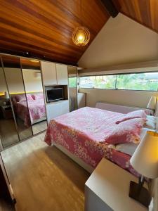 a bedroom with a bed and a tv in it at Bangalô aconchegante e luxuoso Winterville Resort Gravatá PE in Gravatá