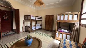 a living room with two bunk beds and a table at Emallayan Hostel in Imsouane