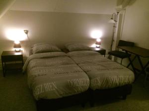 a bed in a hotel room with two lamps at De Distelhoeve in Helvoirt