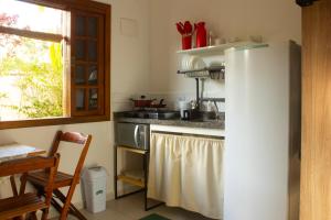 a kitchen with a refrigerator and a stove at Balangan Flats in Ubatuba