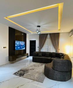 een woonkamer met een bank en een flatscreen-tv bij D-Lezzubra Luxury Apartments in Gwarinpa