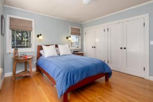 a bedroom with a bed with a blue comforter at Classic Palo Alto Home & Neighborhood in Palo Alto +29 photos