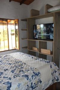 a bedroom with a bed with a tv on the wall at Alma Casa Finca in Guarne +36 photos