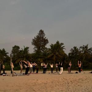 a group of people doing yoga on the beach at Coconut Bay Marari in Mararikulam