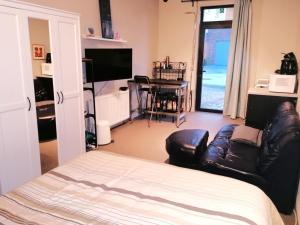 a living room with a couch and a chair and a television at Apartment with a view of alpacas in Heers +19 photos