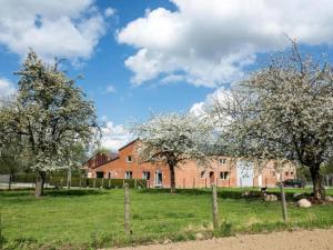 a red brick building with trees in a field at Apartment with a view of alpacas in Heers