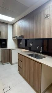阿布扎比Luxury apartment Raha的带水槽和木质橱柜的厨房