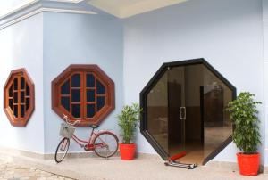 a bike parked next to a wall with two potted plants at Angkor Gecko's Inn Hotel & Guesthouse in Siem Reap