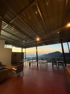 a room with chairs and tables and a view of the ocean at บ้านไร่นายสิงห์-Banrainaysing in Ban Huai Khai