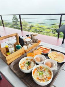 a tray with bowls of food on a table at บ้านไร่นายสิงห์-Banrainaysing in Ban Huai Khai