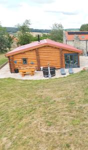 a cabin with a picnic table and chairs in front of it at The Barn & The Log Cabin, Sleeps 12, 2 Hot Tubs, Near Durham & Bishop Auckland in Durham