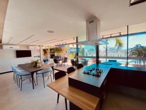 a kitchen and dining room with tables and chairs at Edifício SKY Acomodações in Maceió