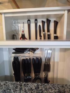 a shelf with knives and utensils on it at Casa 2 Quintas do Poente Serra Negra SP in Serra Negra