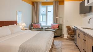 a hotel room with a bed and chairs and a kitchen at The Gilmore, an AvantStay Hotel in Nashville