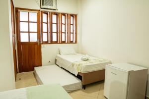 a room with two beds and a window at Pousada do Itaguá in Ubatuba