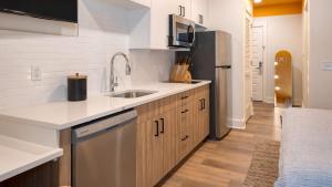 a kitchen with a sink and a refrigerator at The Gilmore, an AvantStay Hotel in Nashville