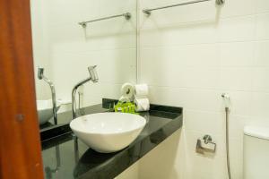 a bathroom with a bowl on a counter next to a toilet at Pousada do Itaguá in Ubatuba