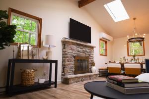 un salon avec une cheminée en pierre et une télévision dans l'établissement Romantic Mountainside Cozy Cabin Poconos, à Gouldsboro