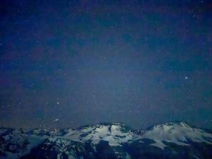 Un cielo nocturno lleno de estrellas y montañas cubiertas de nieve. en HOM Frente a la cordillera depto 7PAX Cerca de las Pista de SKY, en Lo Barnechea 50 fotos más