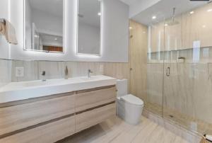 a bathroom with a sink and a toilet and a mirror at Modern Home 3BR 2BA - 20 Min to NYC in Jersey City