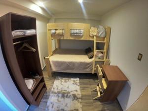 a small room with a bunk bed and a table at Samana Wasi in Cusco